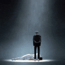 a man standing next to a person laying on the ground