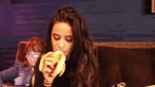 a woman is eating a banana in a dark room .