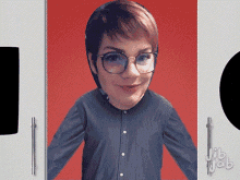 a woman wearing glasses and a blue shirt stands in front of a red background and a white cabinet