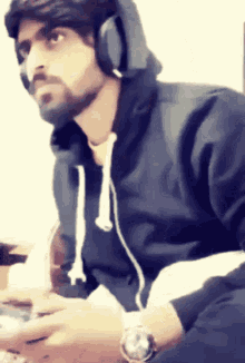 a man wearing headphones and a watch is looking at something
