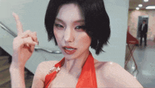 a woman in a red dress points her finger up