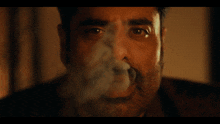 a man with a beard is smoking a cigar