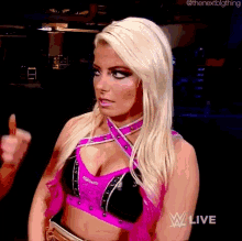 a blonde woman in a pink and black crop top is giving the middle finger .