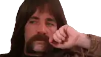 a man with long hair and a beard is holding his hand to his face