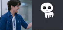 a man in a blue shirt is smiling next to a picture of an alien