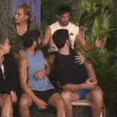 a group of people are sitting in a circle and one of them is hugging another man