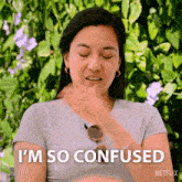 a woman says i 'm so confused in front of a netflix logo