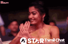 a woman is clapping her hands in front of a star tamil chat logo