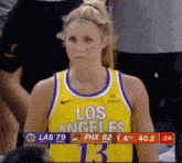 a woman wearing a los angeles jersey looks at the camera