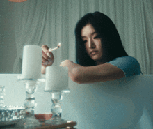 a woman lighting a candle in a candle holder