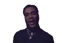 a man wearing a black shirt and a necklace with a diamond pendant
