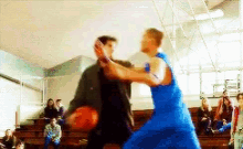 a man in a blue dress is fighting another man in a gym