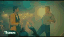 two men are dancing in front of a crowd with the word thanos on the bottom