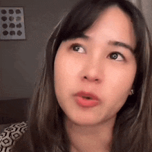 a close up of a woman 's face making a funny face while looking up .