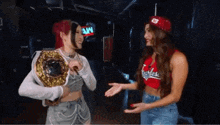 two women are standing next to each other in front of a sign that says aw on it