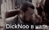 a man in a suit is drinking from a glass with the words dicknoo b y a t e written below him