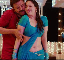 a man in a red shirt is touching a woman 's stomach