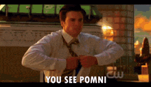 a man in a suit and tie is pointing at his watch and says you see pomni