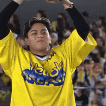 a man wearing a yellow shirt that says " play " on it