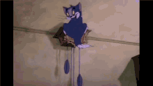 a cuckoo clock with a cartoon cat on top of it