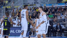 a basketball player with the number 22 on his back shakes hands with another player
