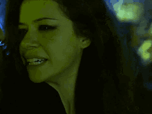 a close up of a woman 's face with a yellow light behind her