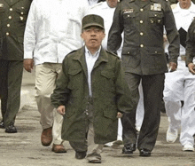 a group of men in military uniforms are walking down a road