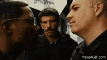 a group of men are standing next to each other .
