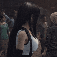a woman in a white tank top is standing in a crowd