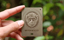 a person holding a card that says modopass with a monkey on it