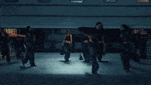 a group of women standing in a dark warehouse
