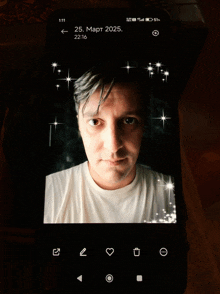 a phone with a picture of a man and the date of march 25