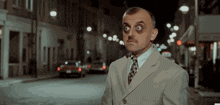 a man in a suit and tie is standing on a street