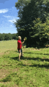 a man in a red shirt is throwing a frisbee in the air