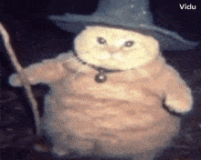 a cat is wearing a wizard hat and holding a stick .