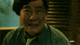 a man in a green shirt and tie is making a funny face in front of a sign that says ' full '