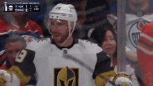 a hockey player with the number 19 on his jersey stands in the stands