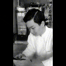 a black and white photo of a man in front of a pepsi refrigerator