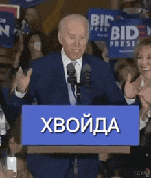 a man stands at a podium with a blue sign that says xboida