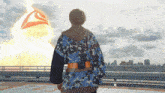 a man in a kimono stands on a rooftop looking at a large explosion