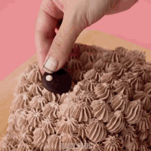 a close up of a person 's hand decorating a chocolate cake with the word easy on the bottom right