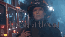 a woman wearing a seattle firefighter 's helmet stands in front of a red fire truck