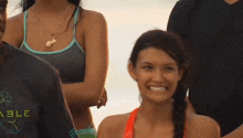 a woman in a bikini is smiling and wearing a necklace that says kylie