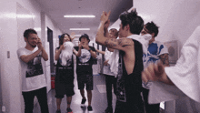 a group of people are standing in a hallway and one of them is wearing a one ok rock shirt