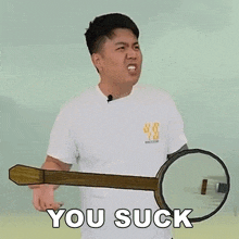 a man in a white shirt is holding a banjo and says you suck .