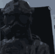 a man wearing a gas mask and a helmet is holding a gun