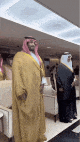 a man in a yellow robe stands next to a man in a black robe
