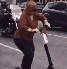 lady pushing riding scooter traffic