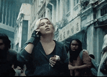 a woman talking on a cell phone in front of a building with chinese characters