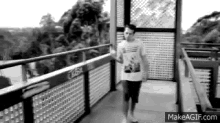 a black and white photo of a man walking down a hallway .